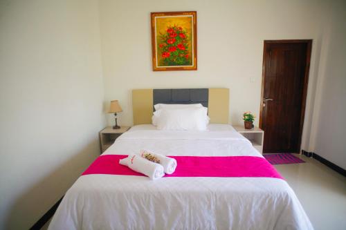 a bedroom with a bed with two towels on it at Pavilla Labuan Bajo in Labuan Bajo