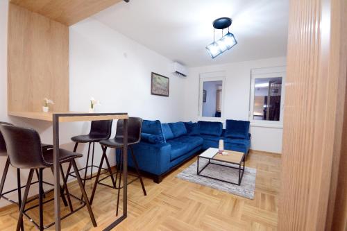 a living room with a blue couch and a table at Cvetkovic LUX Аpartmani & Free GARAŽA in Vrnjačka Banja