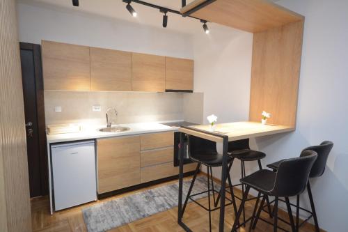 a kitchen with a counter and bar stools in it at Cvetkovic LUX Аpartmani & Free GARAŽA in Vrnjačka Banja