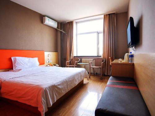 um quarto de hotel com uma cama e uma televisão em 7Days Inn Beijing Yizhuang Development Zone em Pequim