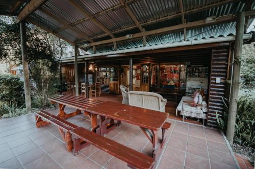 a wooden table and bench on a patio at Tsitsikamma Backpackers in Stormsrivier