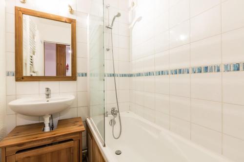 uma casa de banho com um lavatório, uma banheira e um espelho. em Apartment Chamois Blanc 2B em Chamonix-Mont-Blanc