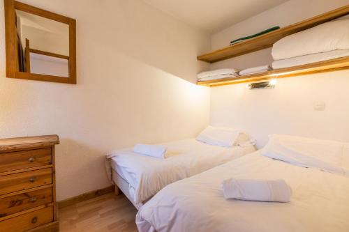 um quarto com 2 camas, uma cómoda e um espelho em Apartment Chamois Blanc 2B em Chamonix-Mont-Blanc