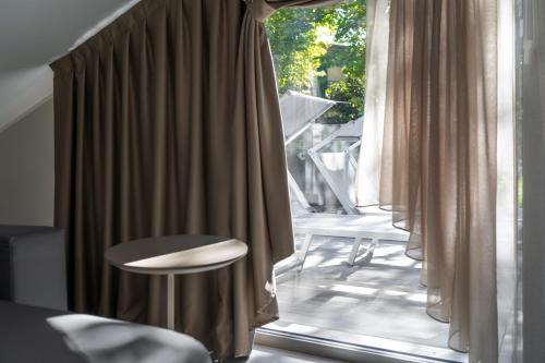 una camera con finestra, tavolo e sedie di Suite Apartment Exclusive a Bellaria-Igea Marina