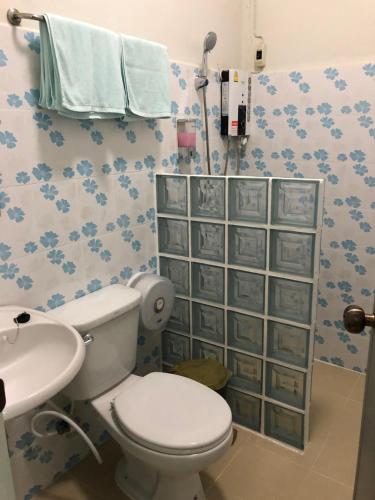 La salle de bains est pourvue de toilettes et d'un lavabo. dans l'établissement Pimpa House, à Ban Hua Nam Mae Sakut