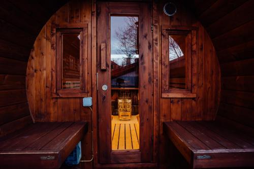 an entrance to a wooden cabin with two benches at Jánošíkova Valaška Hills Apartments in Terchová