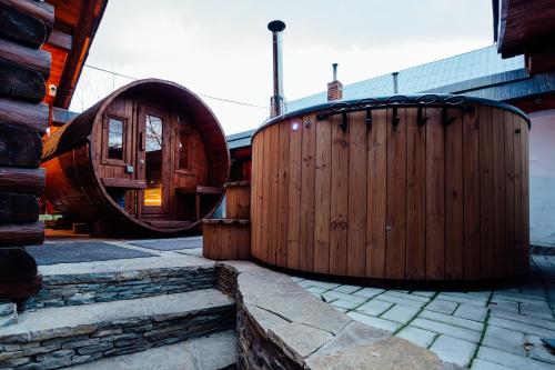 a large wooden building with a wooden barrel at Jánošíkova Valaška Hills Apartments in Terchová