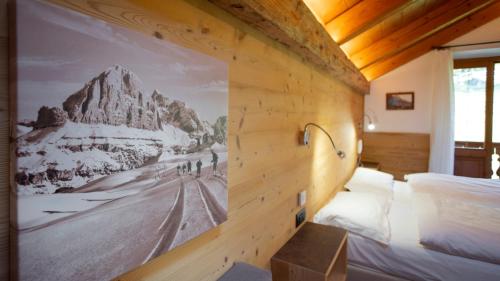 Baita Fraina في كورتينا دامبيتزو: غرفة نوم فيها صورة جبل على الحائط