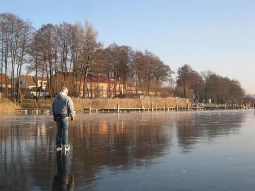 a man is walking on the water at Strandhotel Mirow in Mirow
