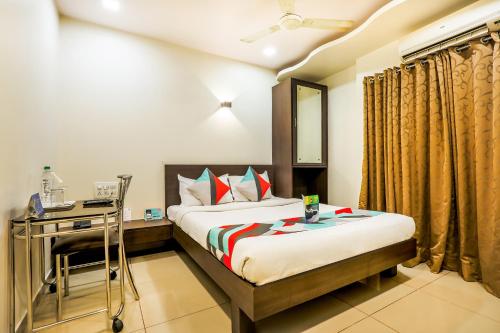 1 dormitorio con cama y escritorio. en FabExpress Adore Inn, en Bombay