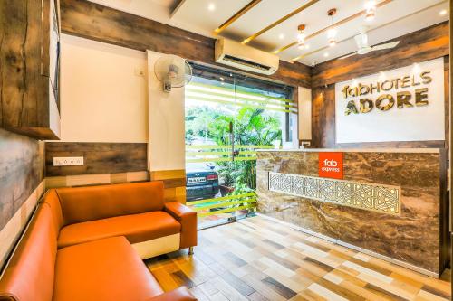 a waiting room at a fast food restaurant with an orange couch at FabExpress Adore Inn in Mumbai