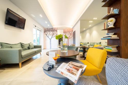 een woonkamer met een gele stoel en een tafel bij Hotel Abc in Cervia