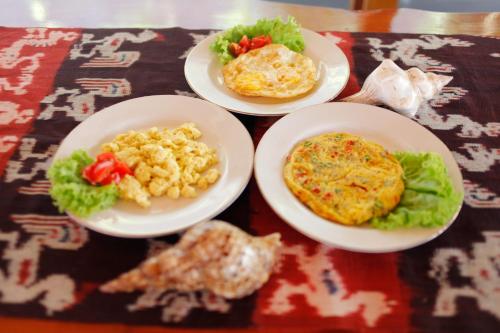 a table with four plates of food on a table at Pavilla Labuan Bajo in Labuan Bajo
