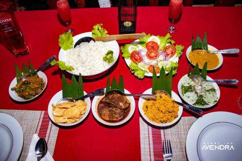 a table with plates of food on a red table at Guest Inn Avendra in Ella