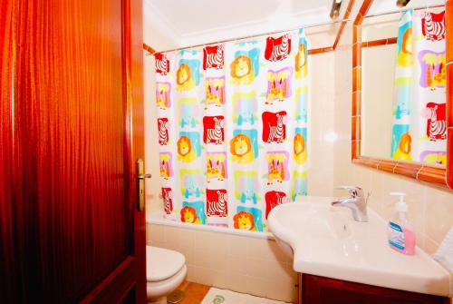 y baño con aseo, lavamanos y cortina de ducha. en Casa Pedro - Baleal beach, Balcony, Pool en Baleal