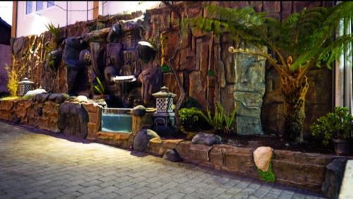 a water fountain in front of a stone wall at Bromo Otix Guest House in Bromo
