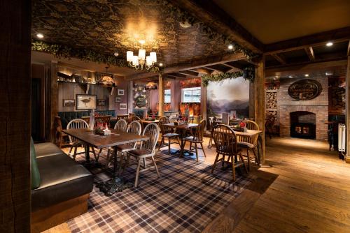 a restaurant with tables and chairs and a fireplace at The Ambleside Inn - The Inn Collection Group in Ambleside