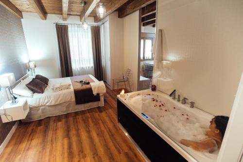 a large bathroom with a tub and a bed at HOTEL RURAL PINARES DE SORIA (Alquiler íntegro) in Molinos de Duero