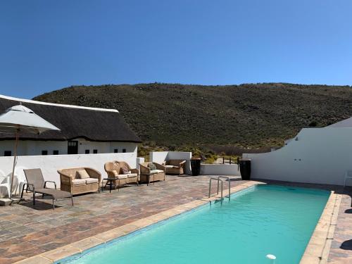 a large white swimming pool sitting next to a house at Karoo 1 Hotel Village in De Doorns