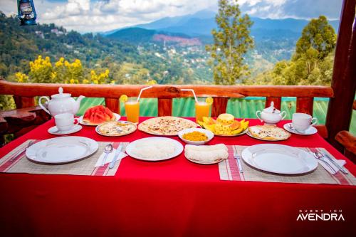 a table with plates of food on a red table cloth at Guest Inn Avendra in Ella