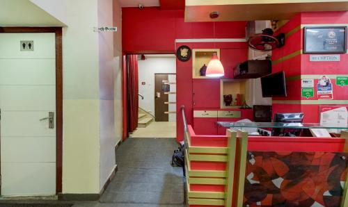 a dining room with red walls and a red counter at Treebo Pawan Putra, Kankurgachi in Kolkata