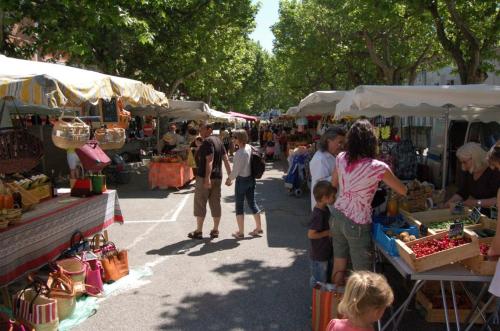 a group of people standing at an outdoor market at Chambre hôtes jacuzzi climatiseur provence in Tulette