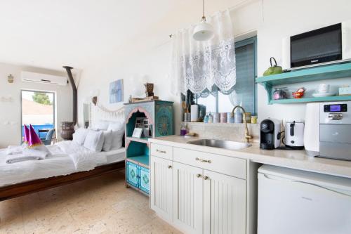a kitchen with a bed and a sink in a room at Point of View in Bruchim Qela' Alon