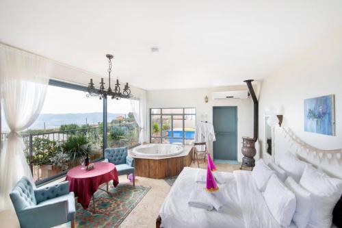 a living room with a tub and a large window at Point of View in Bruchim Qela' Alon