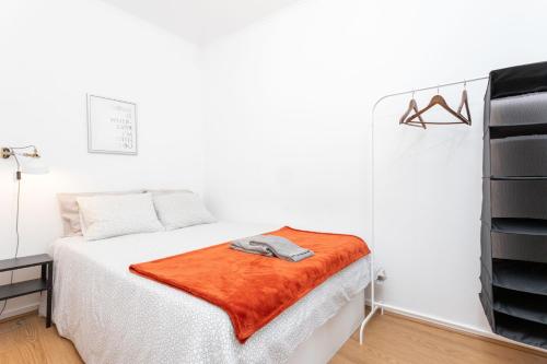 リスボンにあるTravessa do Jardim Apartmentのベッドルーム1室(オレンジの毛布付きのベッド1台付)