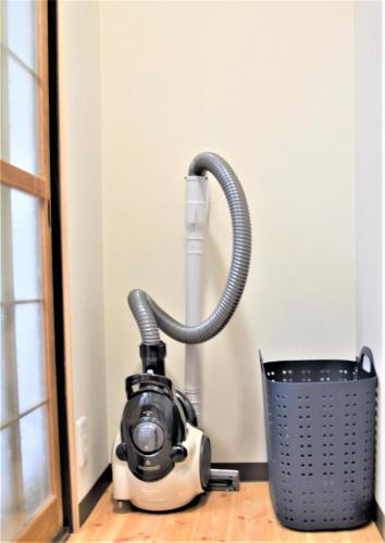 a vacuum cleaner sitting next to a trash can at Osaka U-Shuku in Osaka