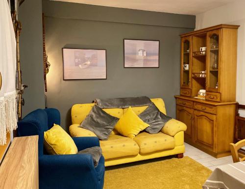 a living room with a yellow couch with pillows on it at Anayet Sweet Home in Formigal