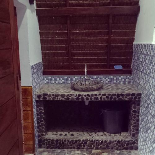 a bathroom with a stone sink on a bench at Orangutan Bungalow in Bukit Lawang