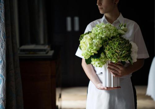 une femme détenant un bouquet de fleurs vertes et blanches dans l'établissement Castello del Sole Beach Resort&SPA, à Ascona