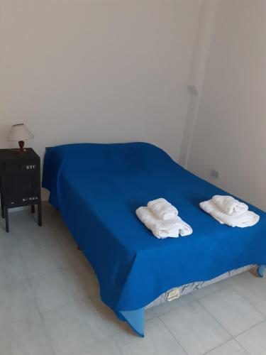 a blue bed with two white towels on it at Roberta 3 in Bahía Blanca
