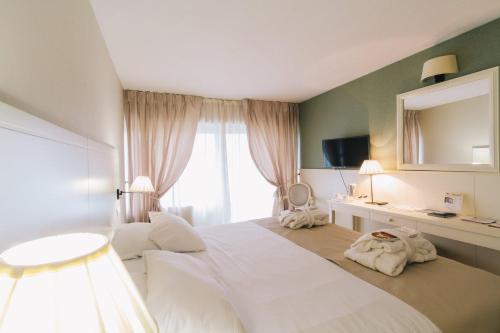 a bedroom with a large white bed and a window at Domaine des Dryades in Pouligny-Notre-Dame