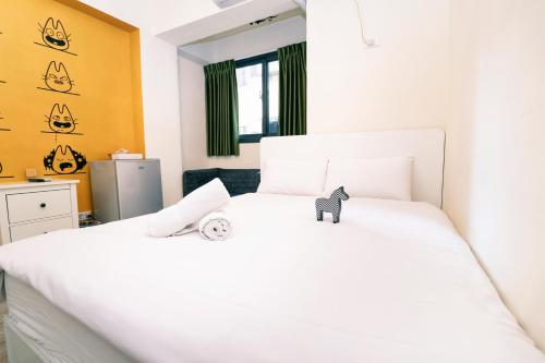a white bed with a cat toy on top of it at Lè mù in Taichung