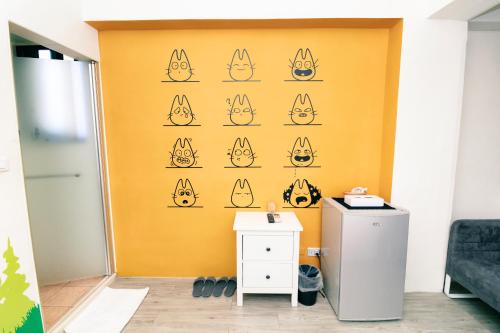 a yellow wall with cats faces painted on it at Lè mù in Taichung