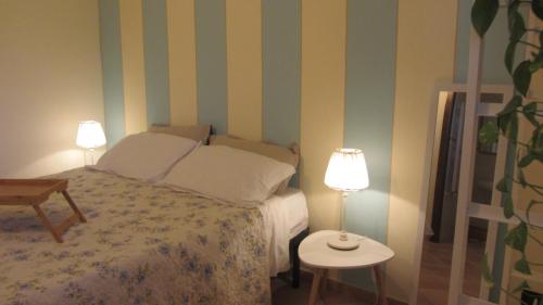 a bedroom with a bed with two lamps and a table at Cascina Bellezza in Poirino