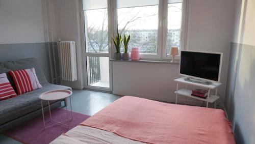 a small living room with a couch and a television at Lovely Madly Apartment in Krakow