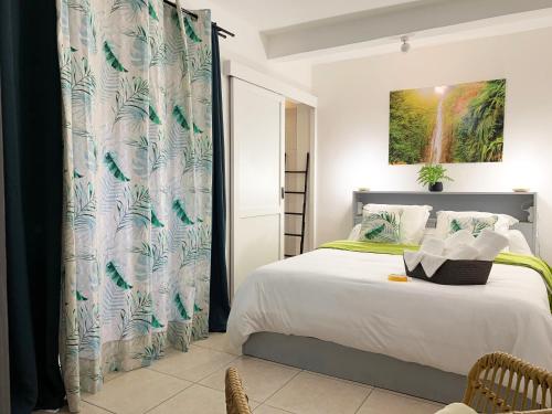 a bedroom with a bed and a shower curtain at Le ZANDOLI (Appartement avec vue) in Petit-Bourg