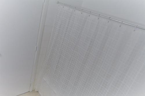een douche met een wit douchegordijn in de badkamer bij Apartamento T3 Aquazul in Portimão