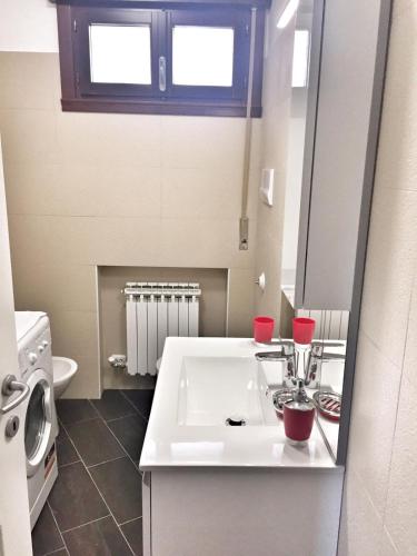 a bathroom with a sink and a washing machine at Red Tower Venice Apartment - 2 mins from VCE Airport- free Wifi in Tessera