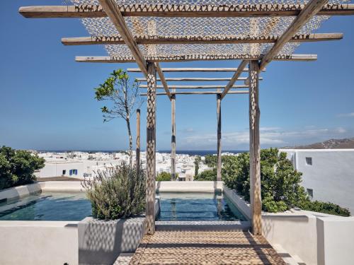 a pergola over a swimming pool on a house at Belvedere Mykonos - Main Hotel - The Leading Hotels of the World in Mýkonos City