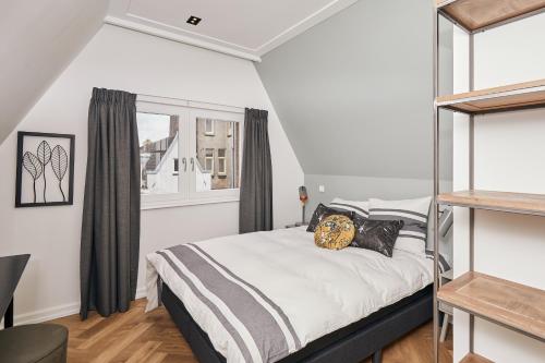 1 dormitorio con cama y ventana en Damrak Short Stay Amsterdam, en Ámsterdam