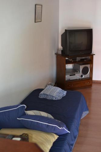 a room with a tv and a bed and a tv stand at SL 1908 in Olivos