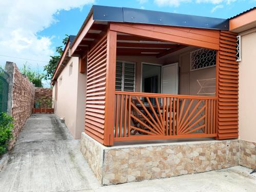 a house with a wooden deck on the side of it at Le ZANDOLI (Appartement avec vue) in Petit-Bourg
