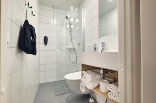 a bathroom with a toilet and a shower and a sink at GreenStar Hotel Vaasa in Vaasa