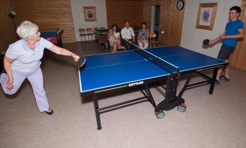 an older woman playing a game of ping pong at Appartement-Hotel Seespitz in Füssen