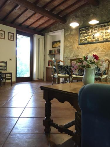 a living room with a table with a vase of flowers on it at Casale Eredità in Orte
