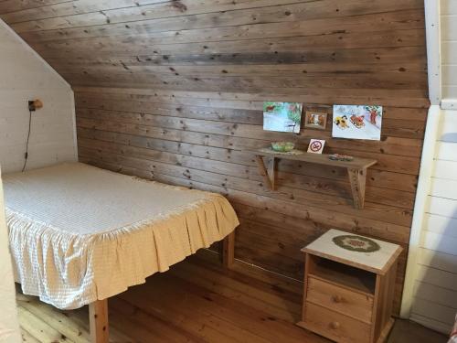 Cette chambre comprend un lit et une table. dans l'établissement Mäe Farm, à Rõuge